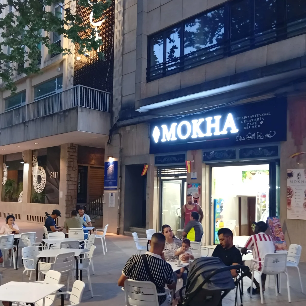 White illuminated MOKHA lettering above a cafe entrance