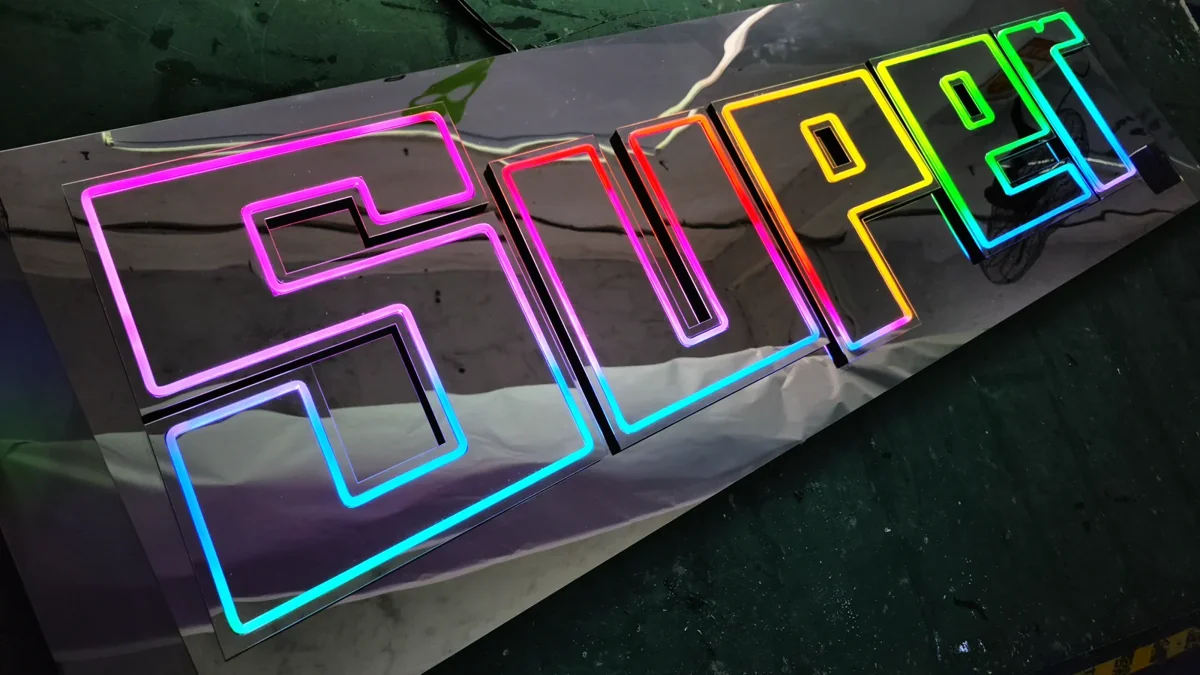 SUPER lettering outlined with coloured light on a workshop surface