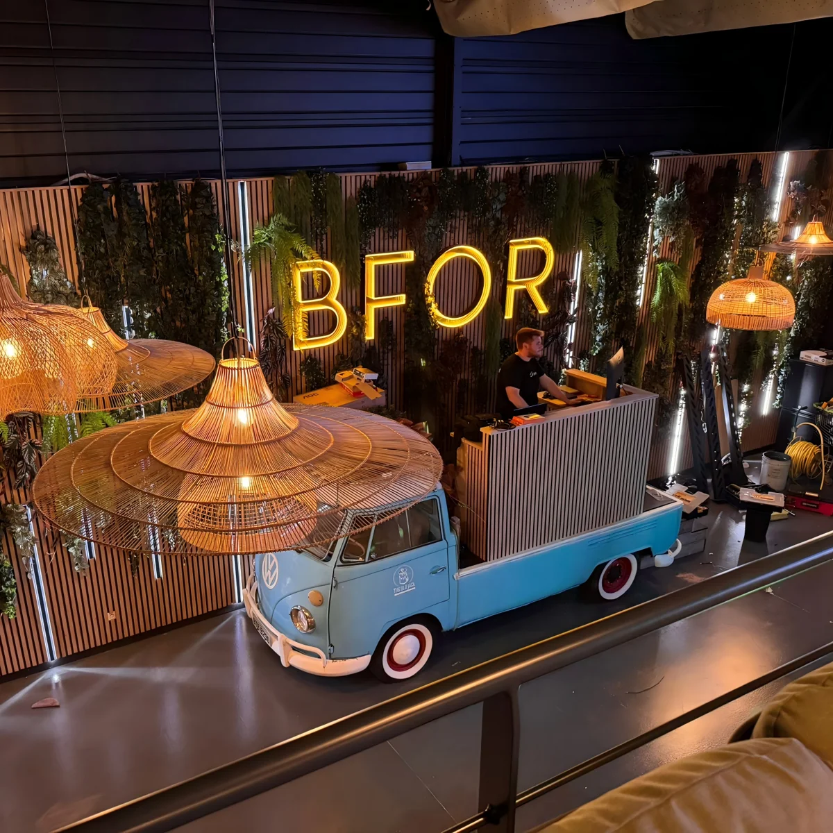 Warm yellow BFOR lettering above a bar counter in a hospitality interior